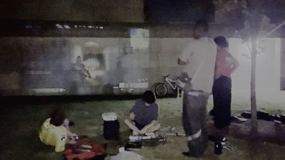 A projection of the game âFortniteâ on the limestone walls of the Wesleyan CFA. A group stands on the grass in front. A man tweaks guitar pedals on the ground.